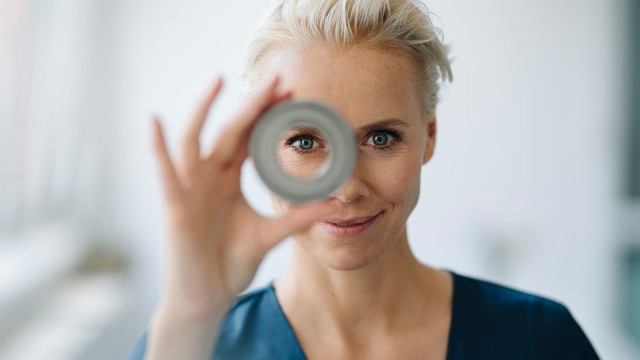 Frau schaut durch eine Rolle