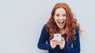 Frau mit Handy lacht