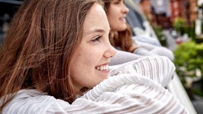 Frau schaut von Balkon runter