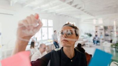 Frau schreibt etwas auf eine Tafel