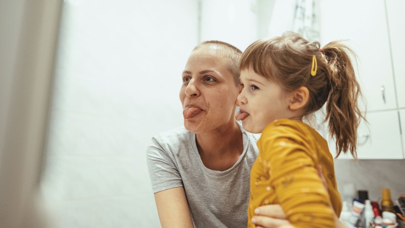 Frau mit Kind strecken Zunge raus