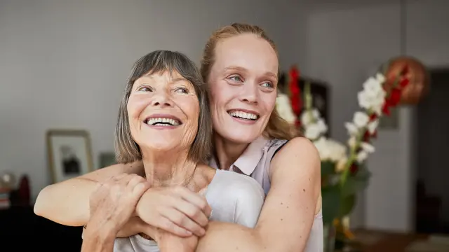 Frau umarmt ältere Frau