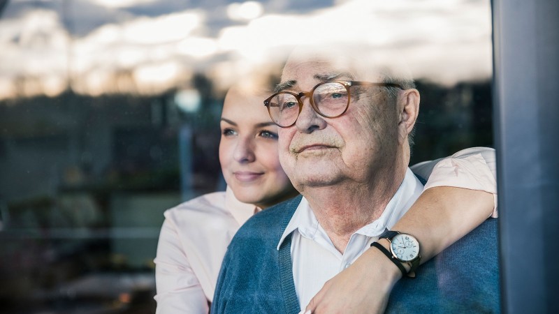 Frau und mann schauen aus dem Fenster