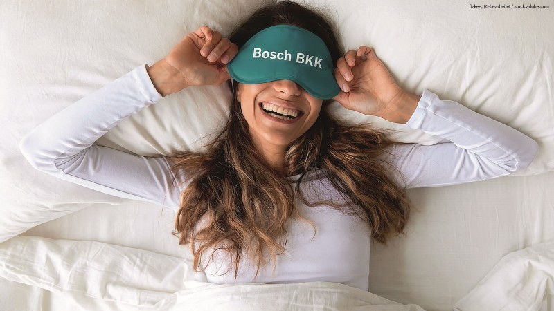 Frau mit Schlafmaske liegt im Bett