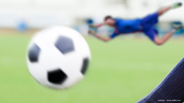 Fußballspieler mit Fußball auf dem Feld