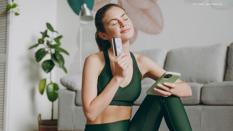 Frau in Sportklamotten mit Kreditkarte