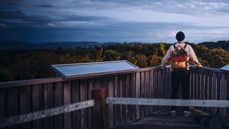 Mann steht alleine auf einer Aussichtsplattform