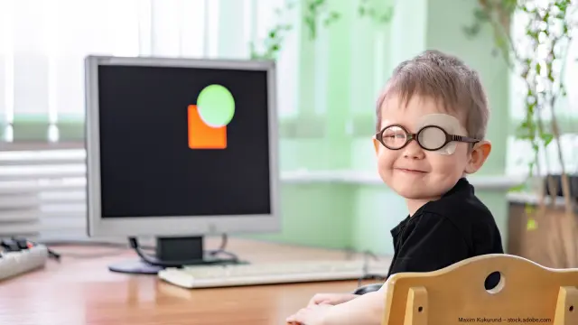 Kind mit Brille vor Computer