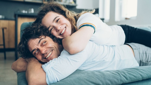 Frau liegt auf dem Rücken von einem Mann.