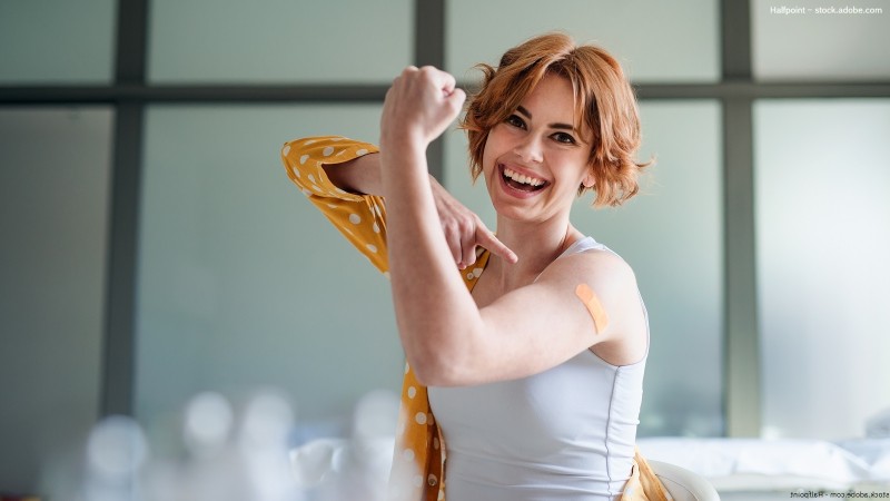 Frau zeigt auf Arm mit Pflaster