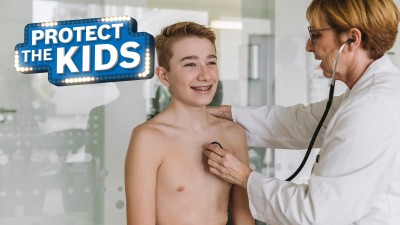 Junge wird von Ärztin untersucht.