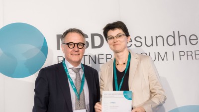 Ein Mitglied der Jury übergibt Abteilungsleiterin Dr. Katja Wimmer den 1. Preis 