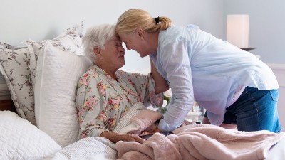Fürsorgliche Begleitung einer älteren Frau im Bett