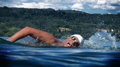 Mann schwimmt kraulend in einem See