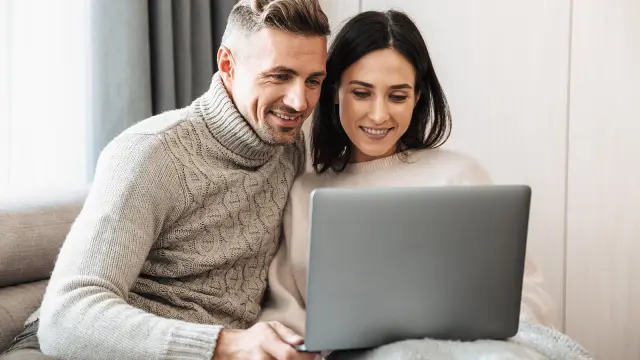 Mann und Frau schauen zusammen in Laptop