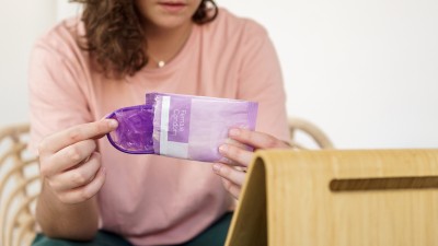 Frau öffnet ein Femidom