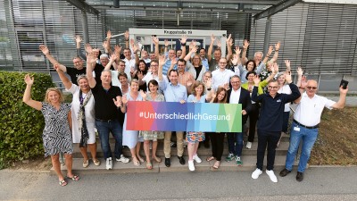 Die Mitglieder des Verwaltungsrates halten ein Schild mit der Aufschrift #UnterschiedlichGesund