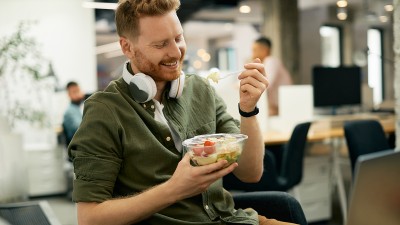 Mann in der Arbeit isst zu Mittag