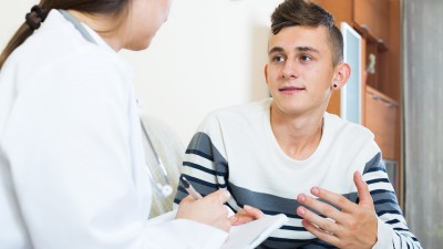 Ein Teenager im Gespräch mit einer Ärztin.