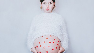 Schwangere Frau mit Herzen auf dem Bauch