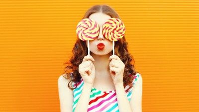 Frau hält zwei Lutscher vor die Augen