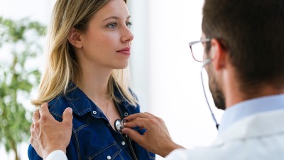 Arzt hört Patientin mit Stethoskop ab