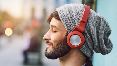Mann mit Kopfhörern und geschlossenen Augen