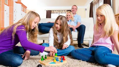 Eine Familie spielt „Mensch, ärgere dich nicht!“