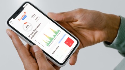 Eine Person hat ein Handy in der Hand. Darauf ist eine App zu sehen, die den Schlaf analysiert. 
