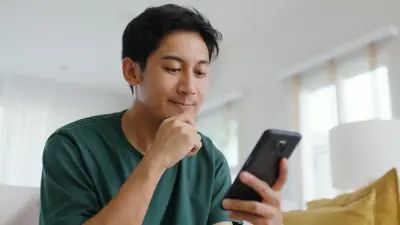 Mann schaut nachdenklich auf sein Handy
