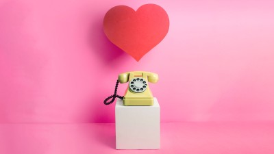 Altes Telefon auf kleinem Podest. Darüber ein rotes Herz.