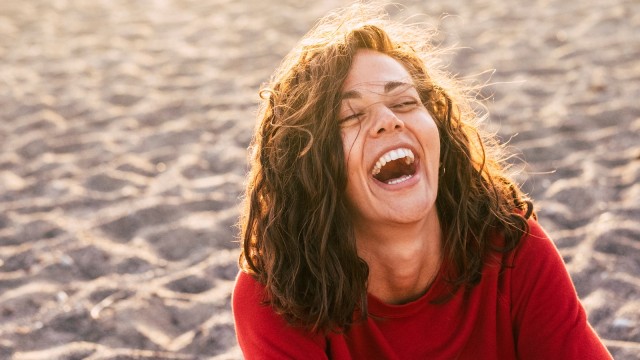 Frau lacht am Strand