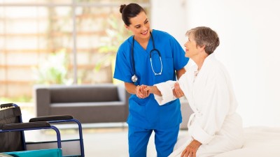 Pflegekraft hilft älterer Frau