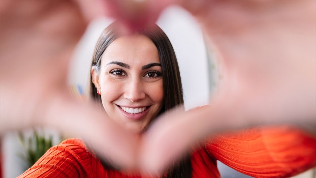Frau macht Herz mit Hand