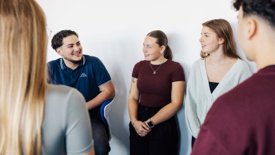 Personen stehen im Kreis und reden